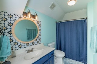 bathroom featuring a shower with shower curtain, vanity, and toilet