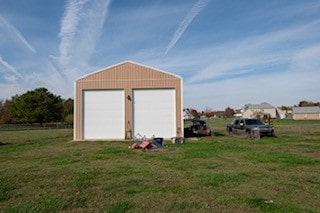 view of outdoor structure featuring a garage and a lawn