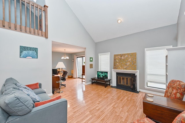 living room with a chandelier, wood-type flooring, and high vaulted ceiling