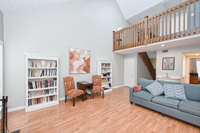 living room with high vaulted ceiling and light hardwood / wood-style flooring