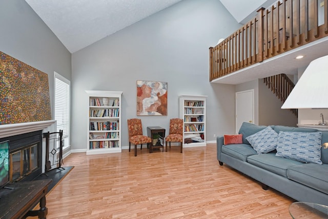 living room with high vaulted ceiling and light wood-type flooring