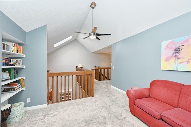 living area with carpet, ceiling fan, and lofted ceiling with skylight