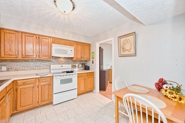 kitchen featuring a textured ceiling, backsplash, light tile patterned floors, and white appliances