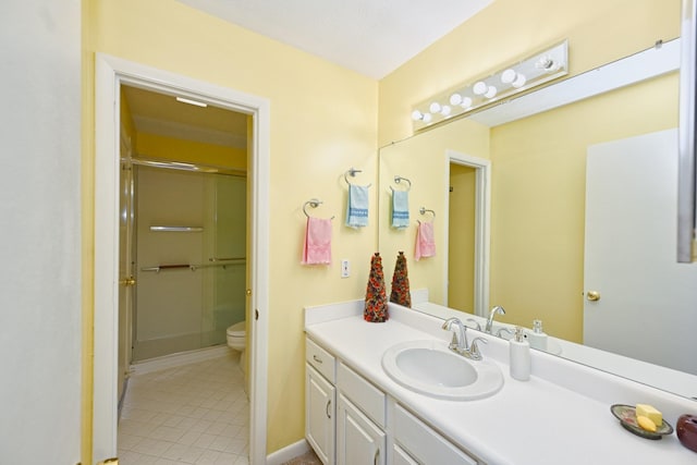 bathroom featuring vanity, toilet, and a shower with shower door