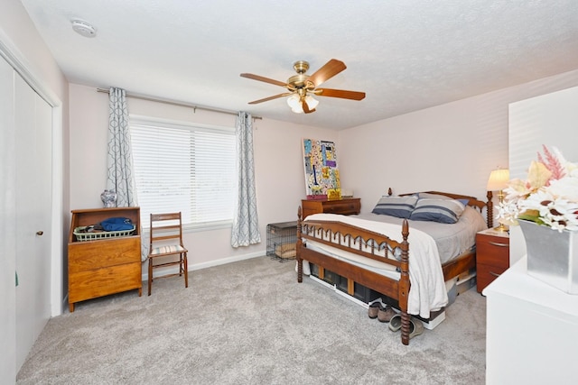 carpeted bedroom featuring ceiling fan, a textured ceiling, and a closet