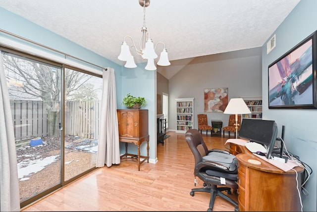 office featuring light hardwood / wood-style floors, vaulted ceiling, a textured ceiling, and a chandelier