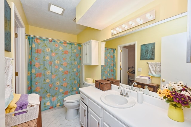 bathroom with tile patterned flooring, vanity, toilet, and a textured ceiling