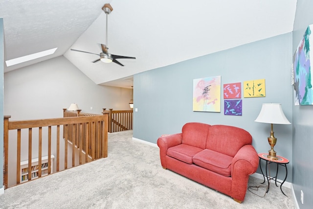 sitting room featuring carpet flooring, ceiling fan, and vaulted ceiling with skylight