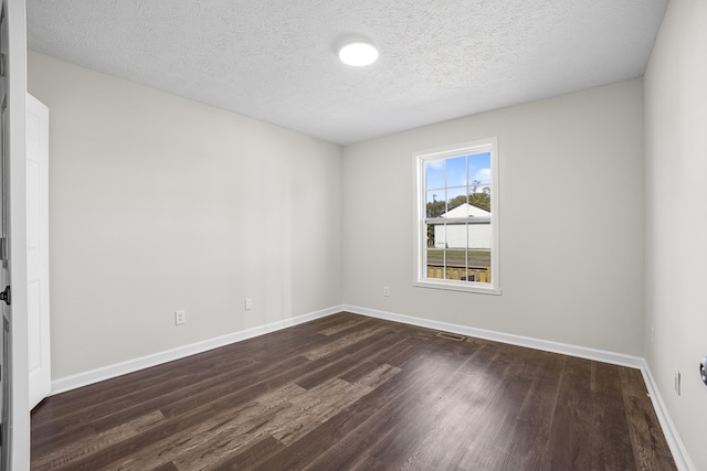 unfurnished room with a textured ceiling and dark hardwood / wood-style floors