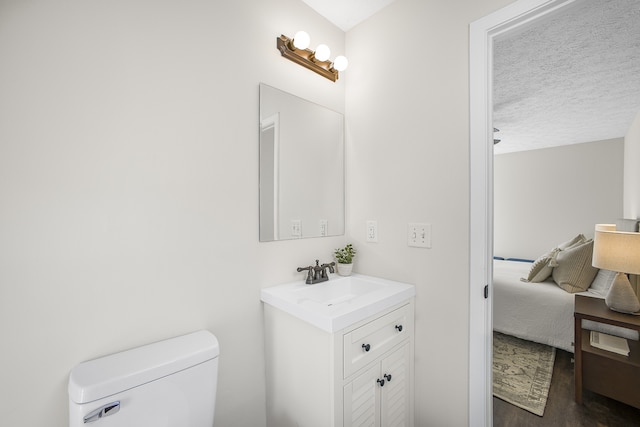 bathroom featuring toilet, a textured ceiling, vanity, and wood-type flooring