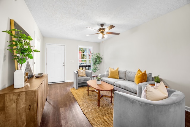 living room featuring ceiling fan, a textured ceiling, and dark hardwood / wood-style floors