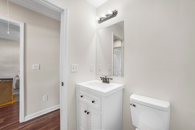 bathroom with toilet, hardwood / wood-style floors, and vanity