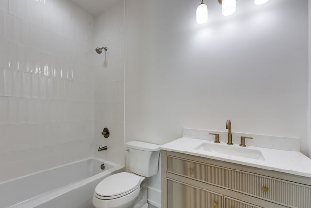 full bathroom featuring tiled shower / bath, vanity, and toilet