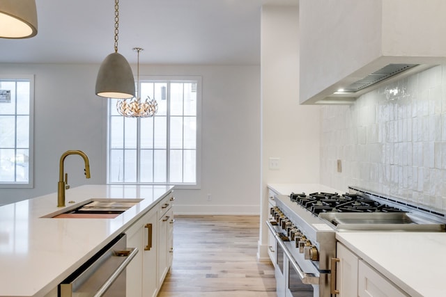 kitchen featuring white cabinets, decorative light fixtures, a healthy amount of sunlight, and appliances with stainless steel finishes