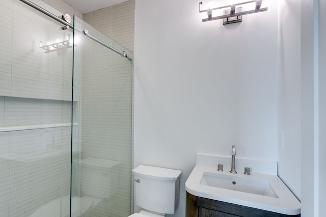 bathroom with vanity, toilet, and a shower with door