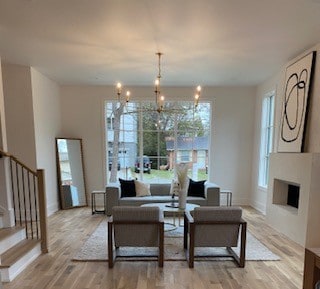 living room featuring a notable chandelier and light wood-type flooring