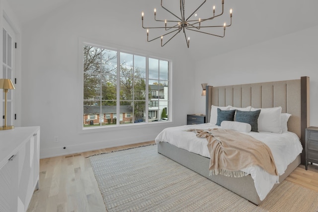 bedroom with light hardwood / wood-style floors and an inviting chandelier