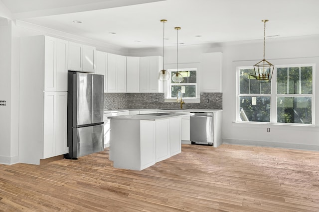 kitchen with light hardwood / wood-style flooring, stainless steel appliances, a center island, decorative light fixtures, and white cabinets