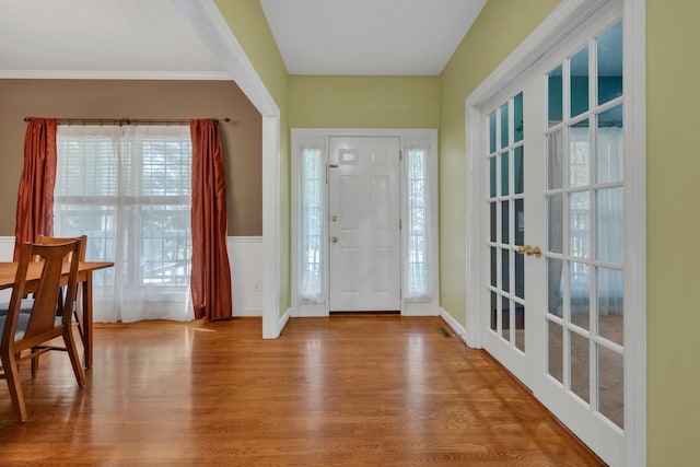 foyer entrance with plenty of natural light, light hardwood / wood-style floors, and crown molding