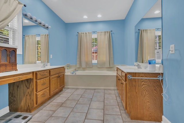 bathroom featuring tile patterned floors, a tub to relax in, vanity, and a healthy amount of sunlight