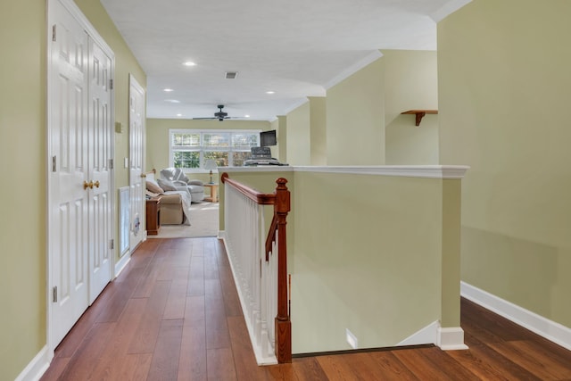 hallway with wood-type flooring and crown molding