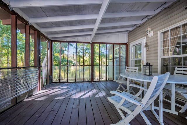 unfurnished sunroom featuring vaulted ceiling with beams and plenty of natural light