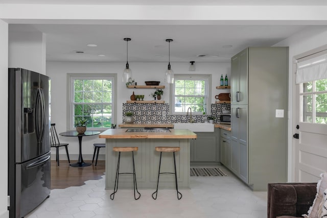 kitchen with sink, wood counters, appliances with stainless steel finishes, and a wealth of natural light