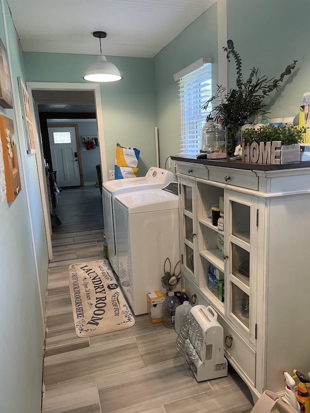 washroom with washing machine and dryer and light wood-type flooring