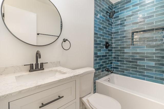 full bathroom with tiled shower / bath, vanity, and toilet