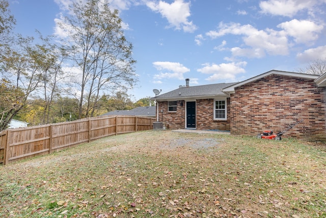 back of property featuring cooling unit and a lawn