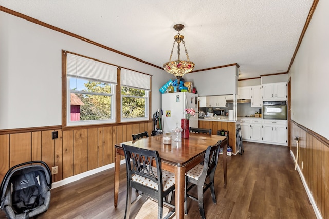 dining room with wood walls, crown molding, and dark hardwood / wood-style flooring