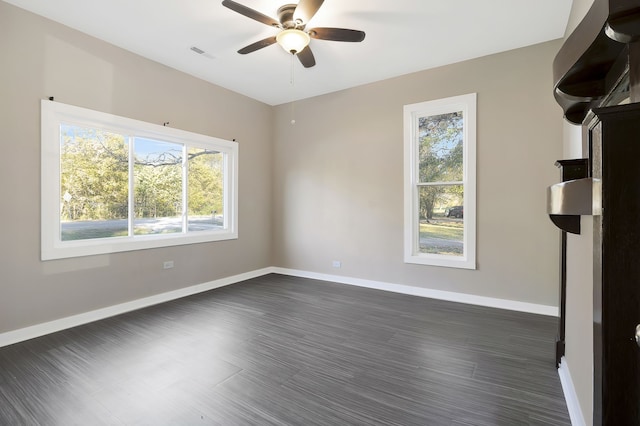 empty room with dark hardwood / wood-style flooring and ceiling fan