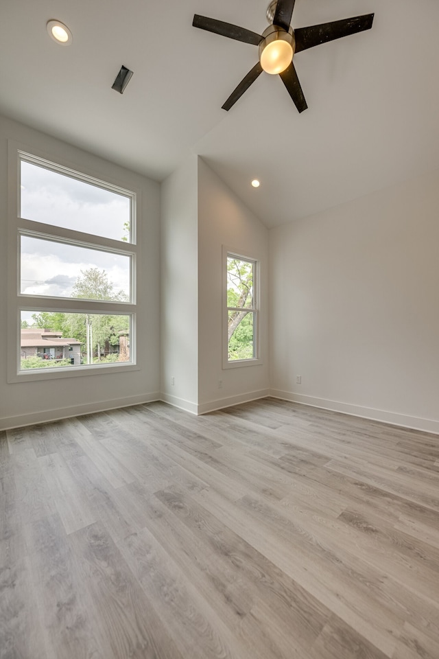 unfurnished room featuring a wealth of natural light, lofted ceiling, light hardwood / wood-style flooring, and ceiling fan