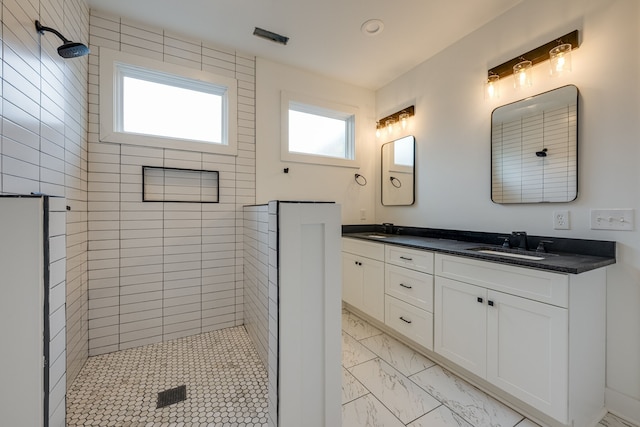 bathroom with vanity, tiled shower, and plenty of natural light