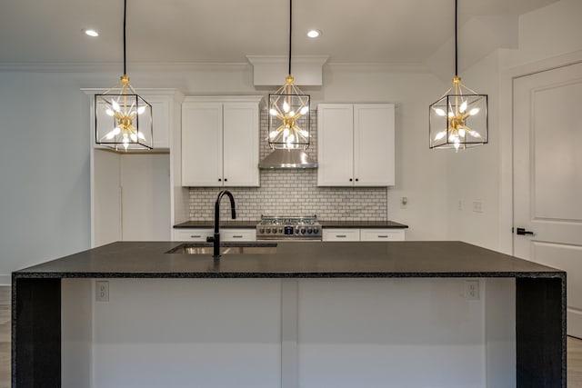 kitchen featuring stainless steel range, a kitchen island with sink, and decorative light fixtures