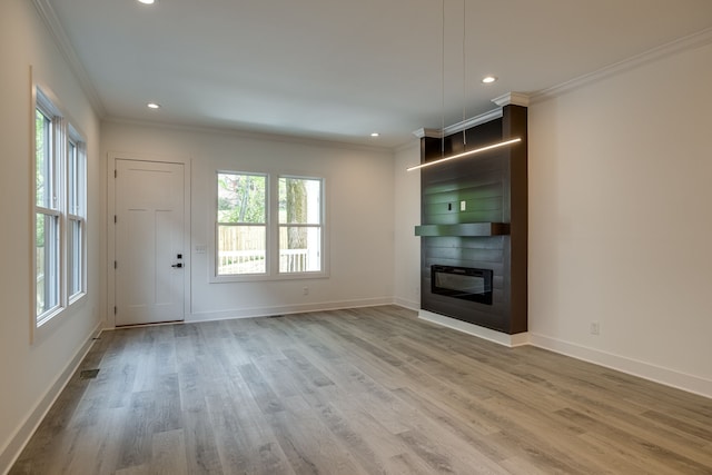 unfurnished living room featuring hardwood / wood-style floors and crown molding