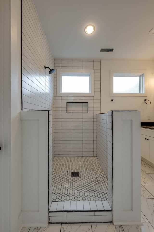 bathroom with a wealth of natural light and a tile shower