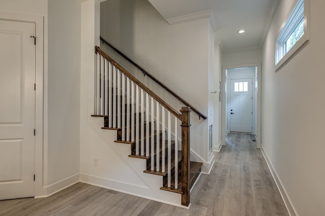 stairway featuring ornamental molding and hardwood / wood-style floors