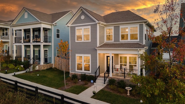 view of front of home featuring a yard, a balcony, and a porch