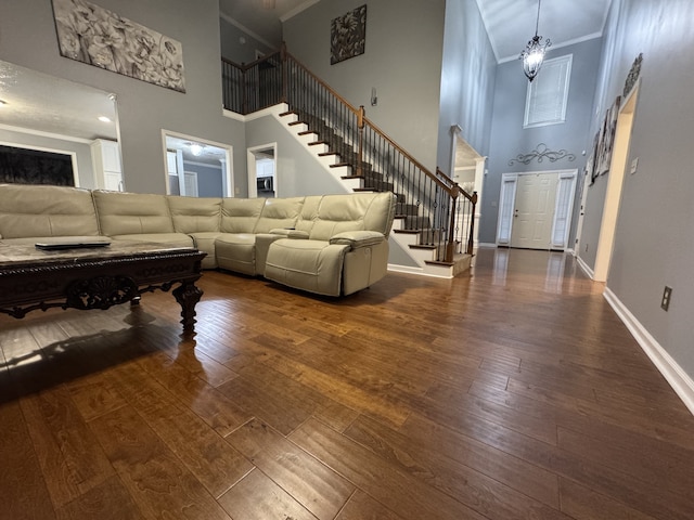 living room featuring ornamental molding, a high ceiling, and dark hardwood / wood-style flooring