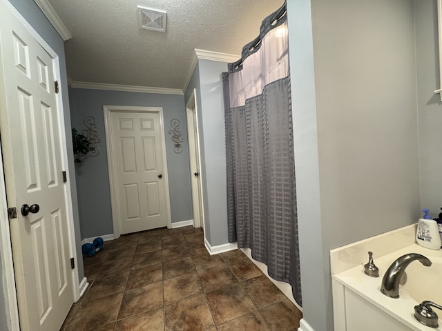 bathroom with crown molding, curtained shower, a textured ceiling, and tile patterned flooring