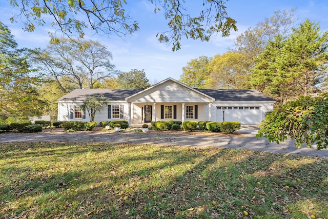 ranch-style house featuring a front lawn and a garage