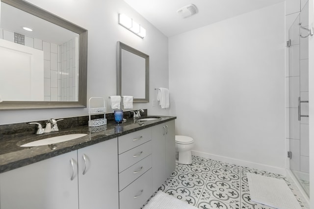 bathroom with vanity, toilet, a shower with shower door, and tile patterned flooring