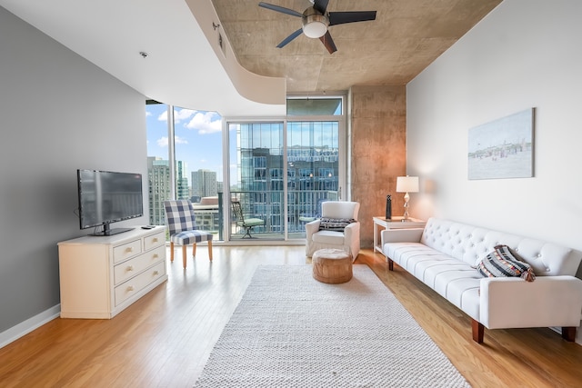 living room featuring floor to ceiling windows, ceiling fan, and light wood-type flooring