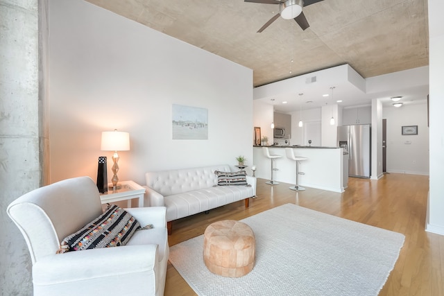 living room with ceiling fan and light wood-type flooring