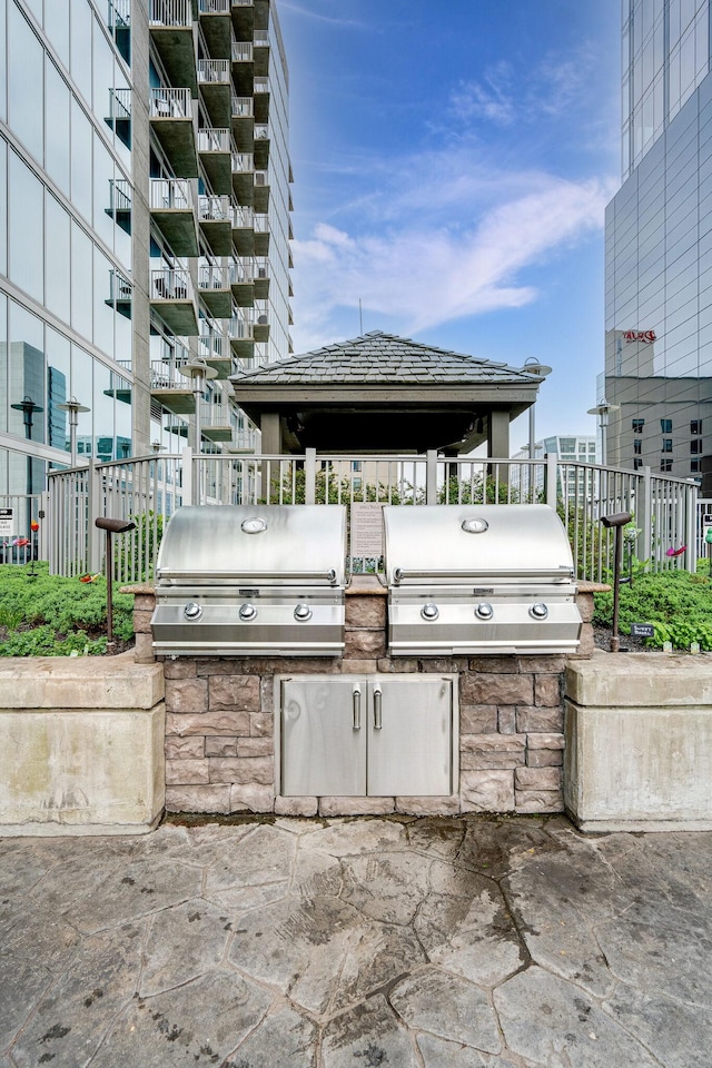 view of patio featuring exterior kitchen, a gazebo, and area for grilling