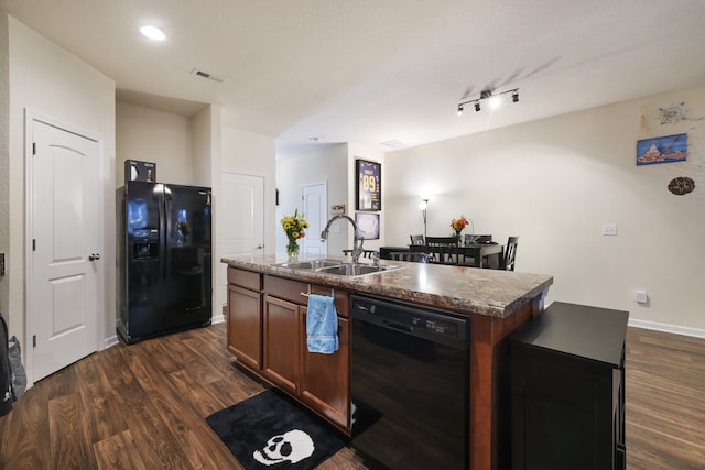 kitchen featuring sink, black appliances, an island with sink, and dark hardwood / wood-style flooring