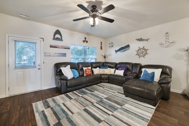 living room featuring dark wood-type flooring and ceiling fan