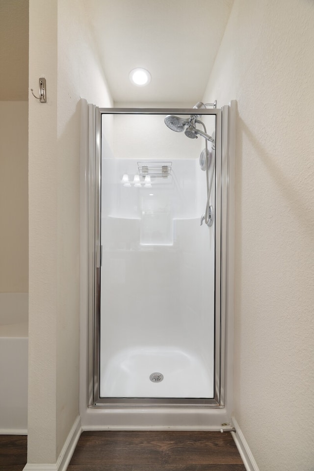 bathroom featuring wood-type flooring and a shower with shower door