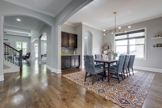 dining room with an inviting chandelier, ornamental molding, and dark hardwood / wood-style flooring